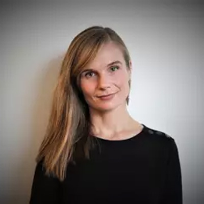 Bilde av Guro Nore Fløgstad. Hun har langt, rett hår og svart topp.