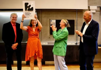 Direktør i Forskningsrådet - Mari Sundli Tveit - feirer statusen som senter for Fremragende Forskning sammen med nobelprisvinnerne Moser.  May Britt Moser holder en plakett der det står SFF over hodet.