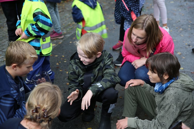 Elever fra 6A på Krohnengen skole i Bergen undersøker nærmiljøet sammen med forsknings- og høyere utdannings minister Iselin Nybø og forsker Marte Haave.