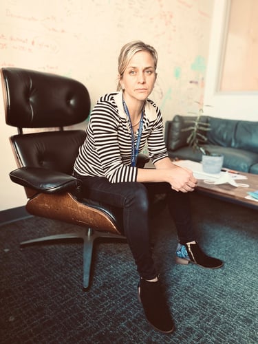 Portrett av kvinne med blondt hår som sitter i en stol