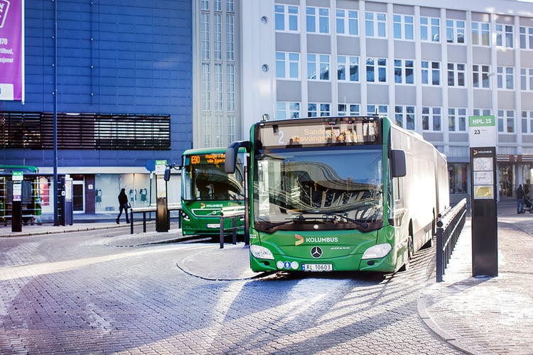 Grønn buss på bussholdeplass