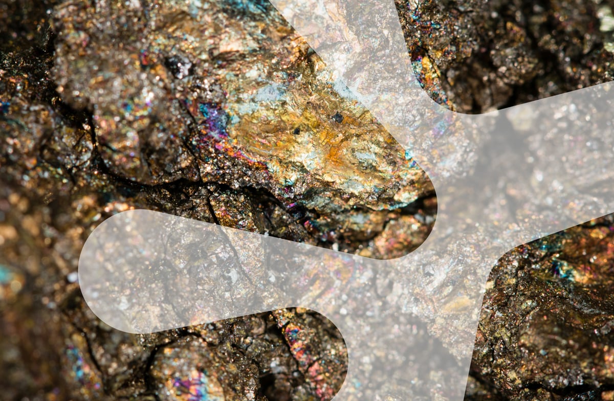 Nærbilde av stein med mineral i. Grafisk hvit dubinform oppå.